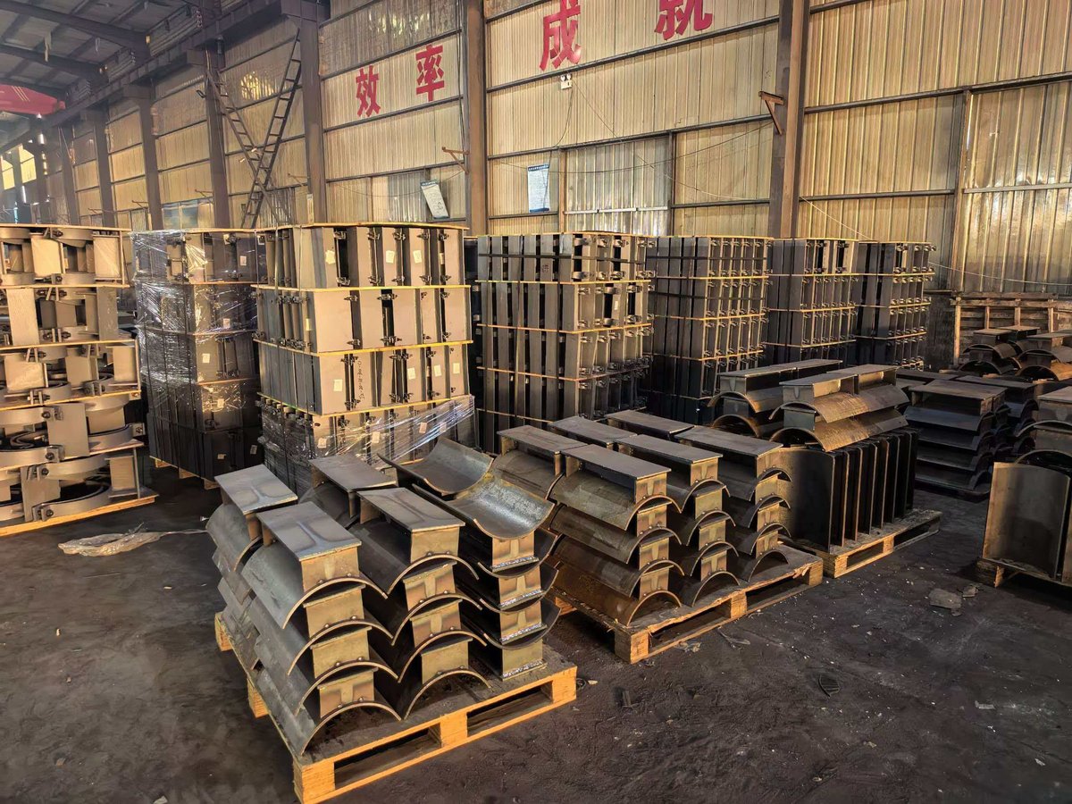 Heavy-duty pipe supports and structural components organized on pallets in factory